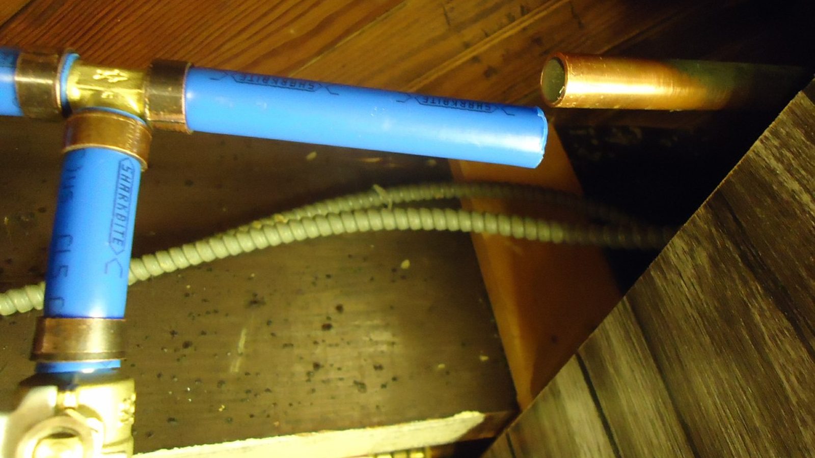 Water supply pipes and shut-off valves in a basement ceiling